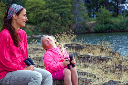 Mother and daughter sitting by a pond