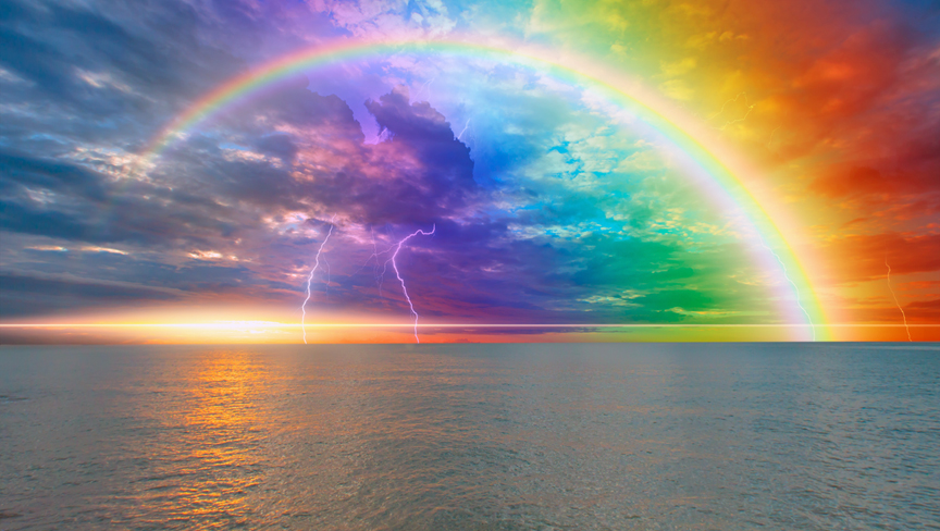 Rainbow over the stormy sea after rain with lightning, calm sea