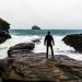 Man facing ocean and waves during a storm
