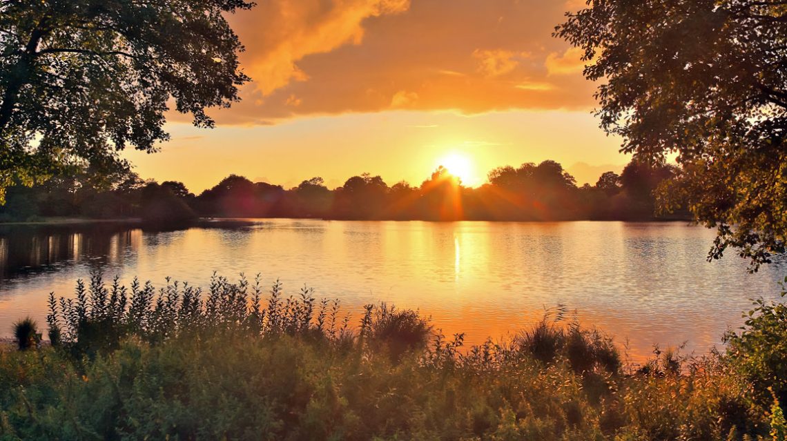 Beautiful and romantic sunset at a lake in yellow and orange colors