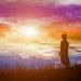 Silhouette of woman praying over beautiful sky background