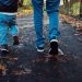 A dad and his son walking in the leaves on a path