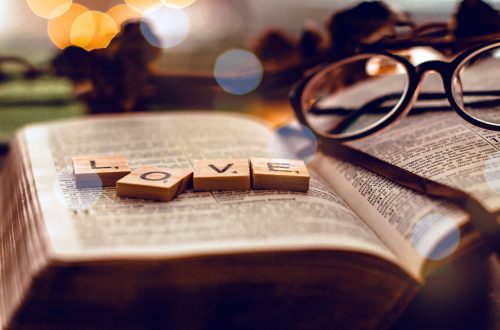Tile letters spell love on top of a Bible