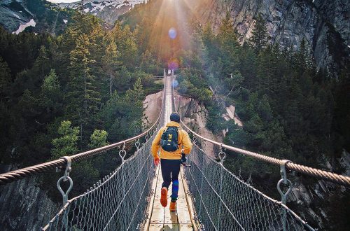 A runner crossing a bridge between mountains