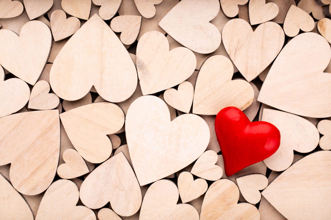 Wooden hearts, one red heart on the wooden heart background