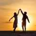 Silhouettes of man and woman dancing on beach