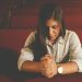 A woman who is kneeling and praying