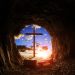 Inside an empty tomb looking outside to the cross