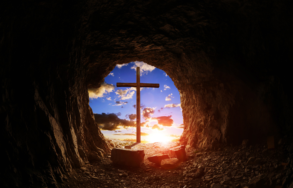 Inside an empty tomb looking outside to the cross