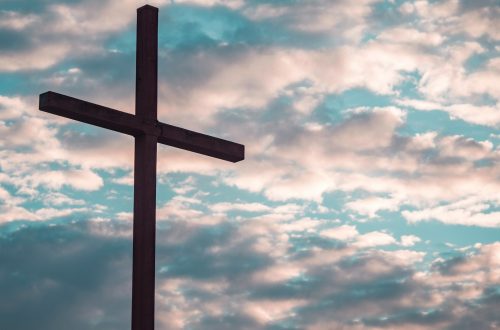 Cross in front of gray and white clouds
