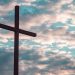 Cross in front of gray and white clouds