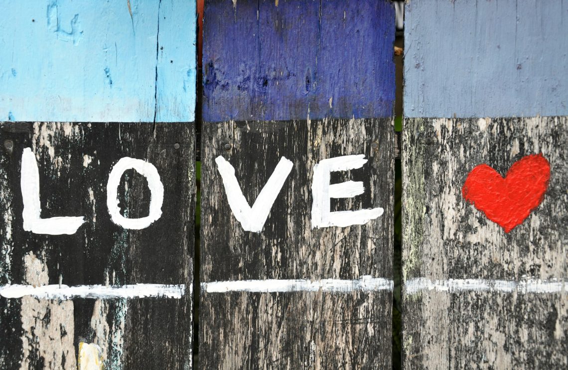 A fence with the word "love" painted on it