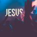 A crowd worshiping Jesus with His name on the wall