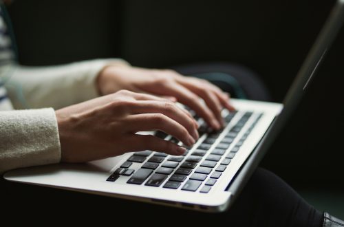 A writer typing on a keyboard