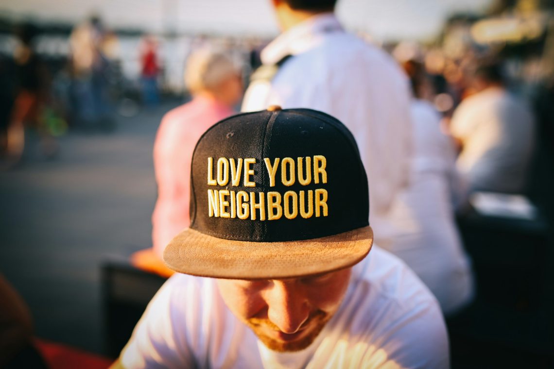 A man wearing a ball cap that says, "Love Your Neighbour"