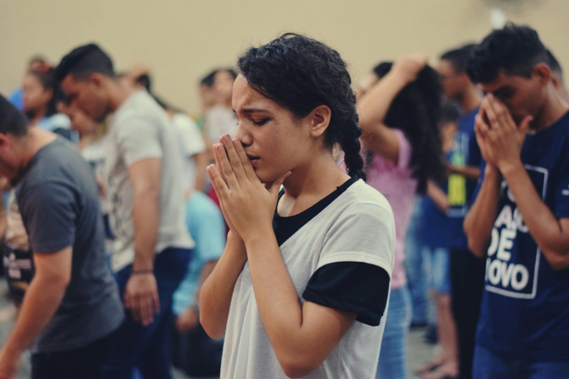A young woman praying in a church service