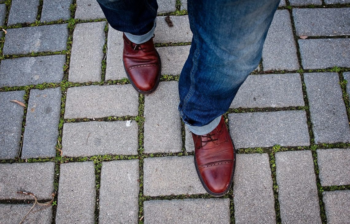 View of a man's shoes as he steps forward