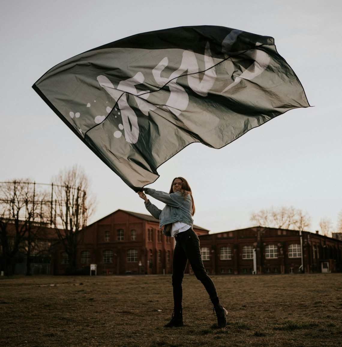A woman is waving a flag that says "Jesus"