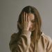 A woman holding her hand against her face in emotional pain