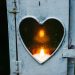 A candle burning in a lantern with a heart window