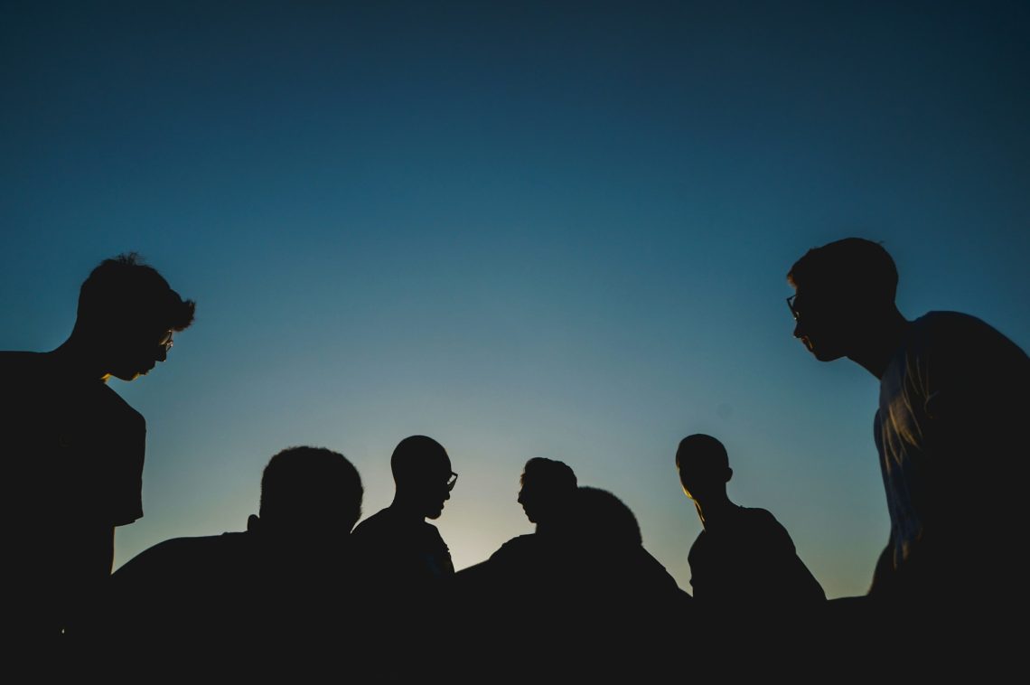 A group of youth in front of a night sky