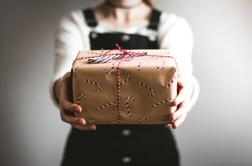A woman holding out a Christmas present