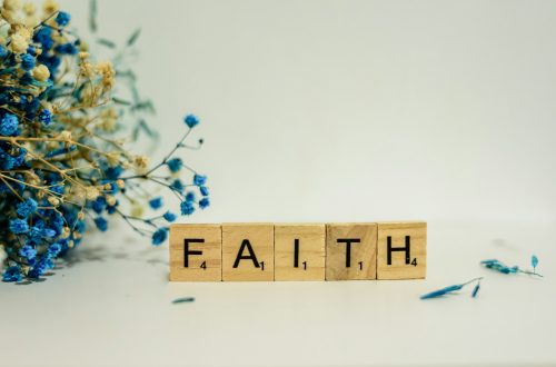 "Faith" spelled on letter tiles next to a dried-flower bouquet