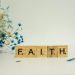 "Faith" spelled on letter tiles next to a dried-flower bouquet