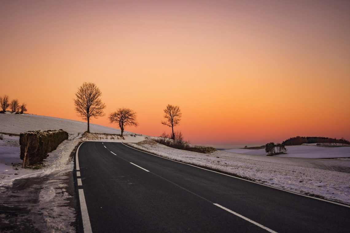 A road, snow, and a sunset