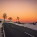 A road, snow, and a sunset