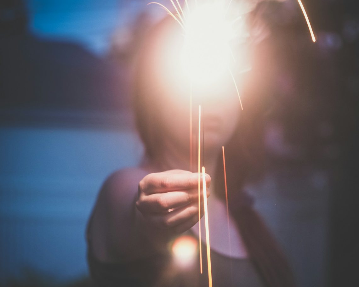 A woman holding a light in front of her face