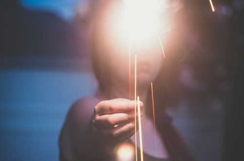 A woman holding a light in front of her face