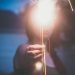 A woman holding a light in front of her face