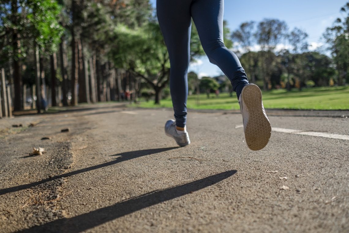 A woman running in a park on the pavement