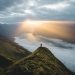 A person standing on a mountaintop watching the sunrise