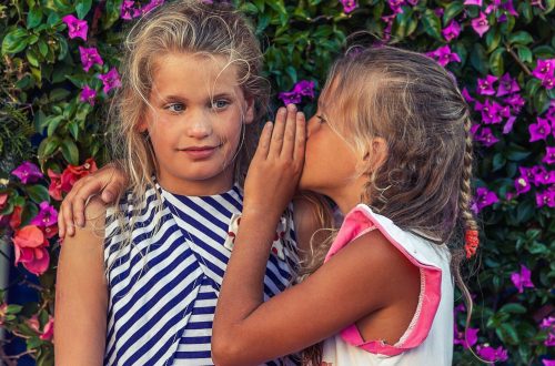A little girl sharing a secret with another little girl