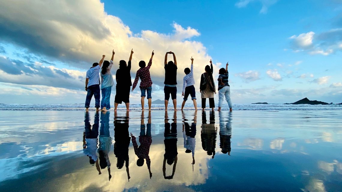 Group of people cheering together on the beach