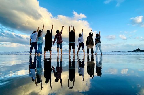 Group of people cheering together on the beach