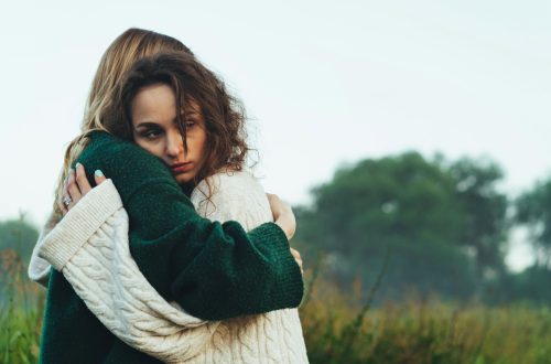 A sad woman hugging a friend
