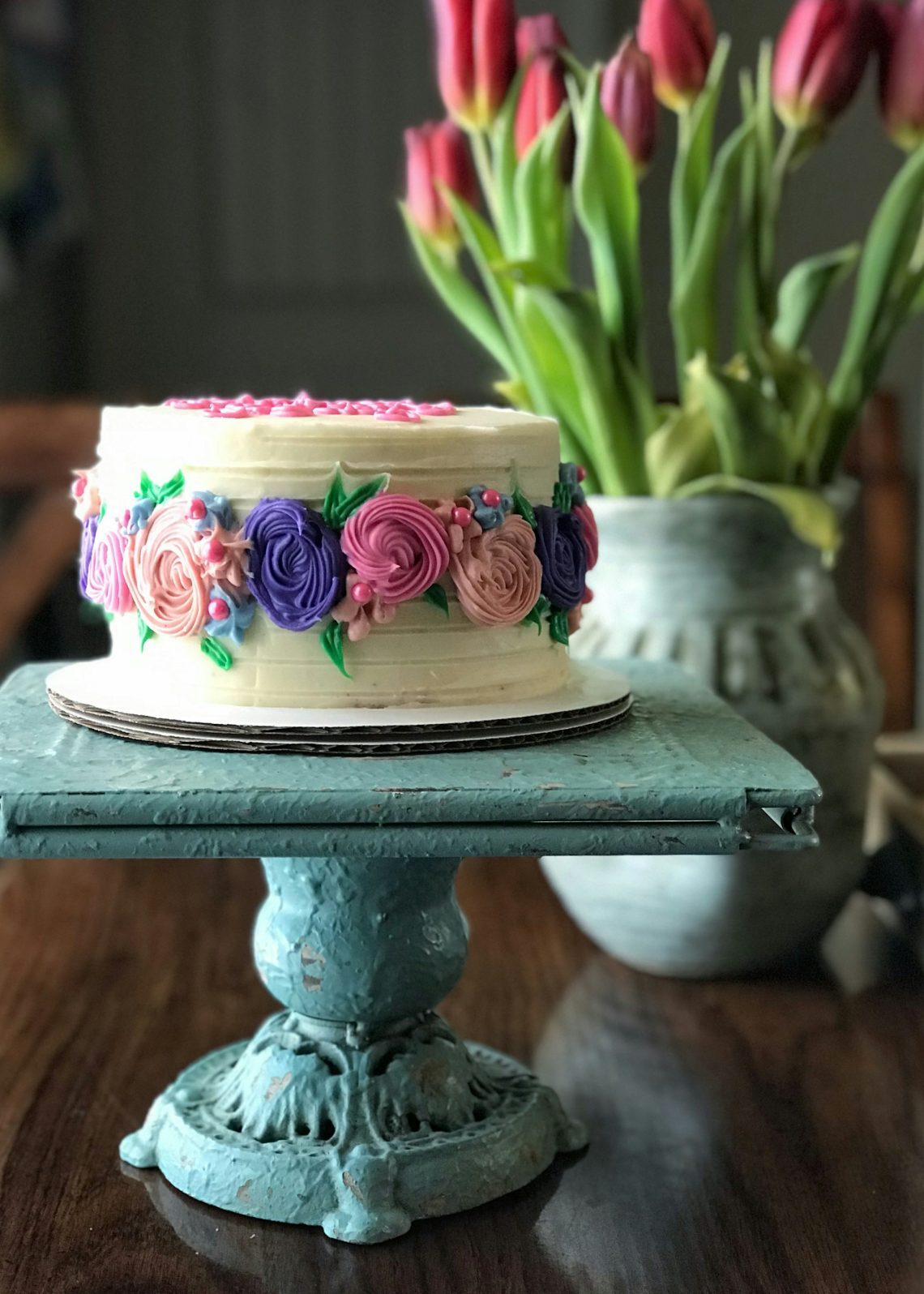 An elegant birthday cake on a blue platter