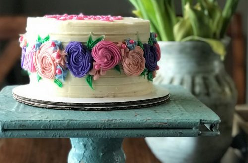 An elegant birthday cake on a blue platter