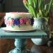 An elegant birthday cake on a blue platter