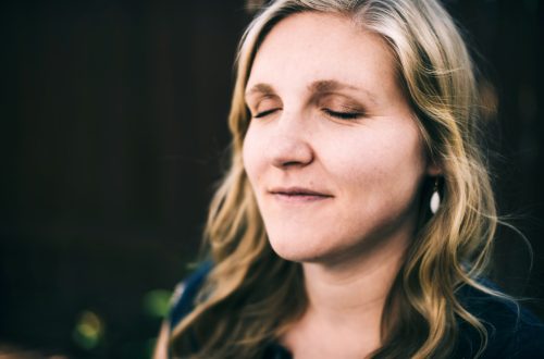 A woman is praying silently and smiling at the same time