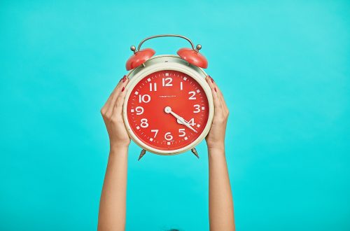 Woman holding up a red and white clock