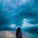 A woman standing in front of a stormy sky