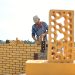 Man laying brick to build a wall