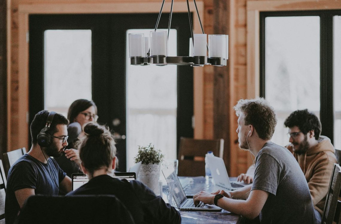 A group of people sit around a table to work