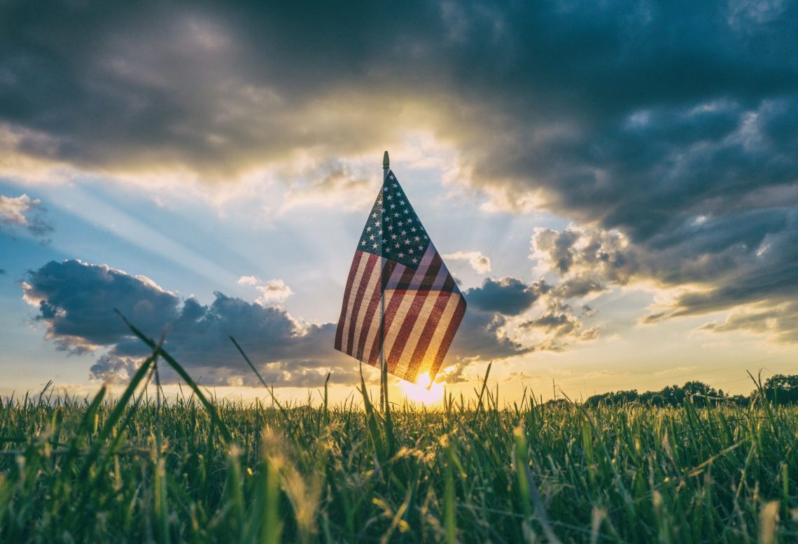 American flag on meadow at sunrise