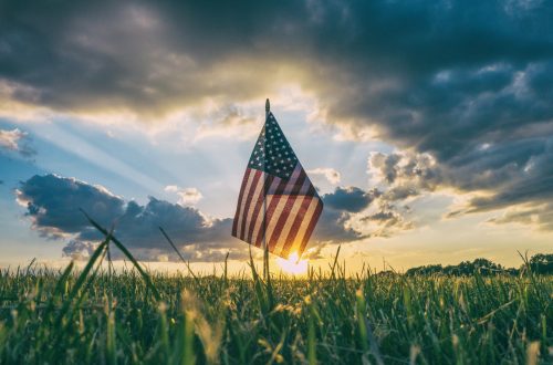 American flag on meadow at sunrise