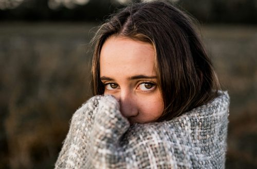 A woman standing and wrapped in a blanket